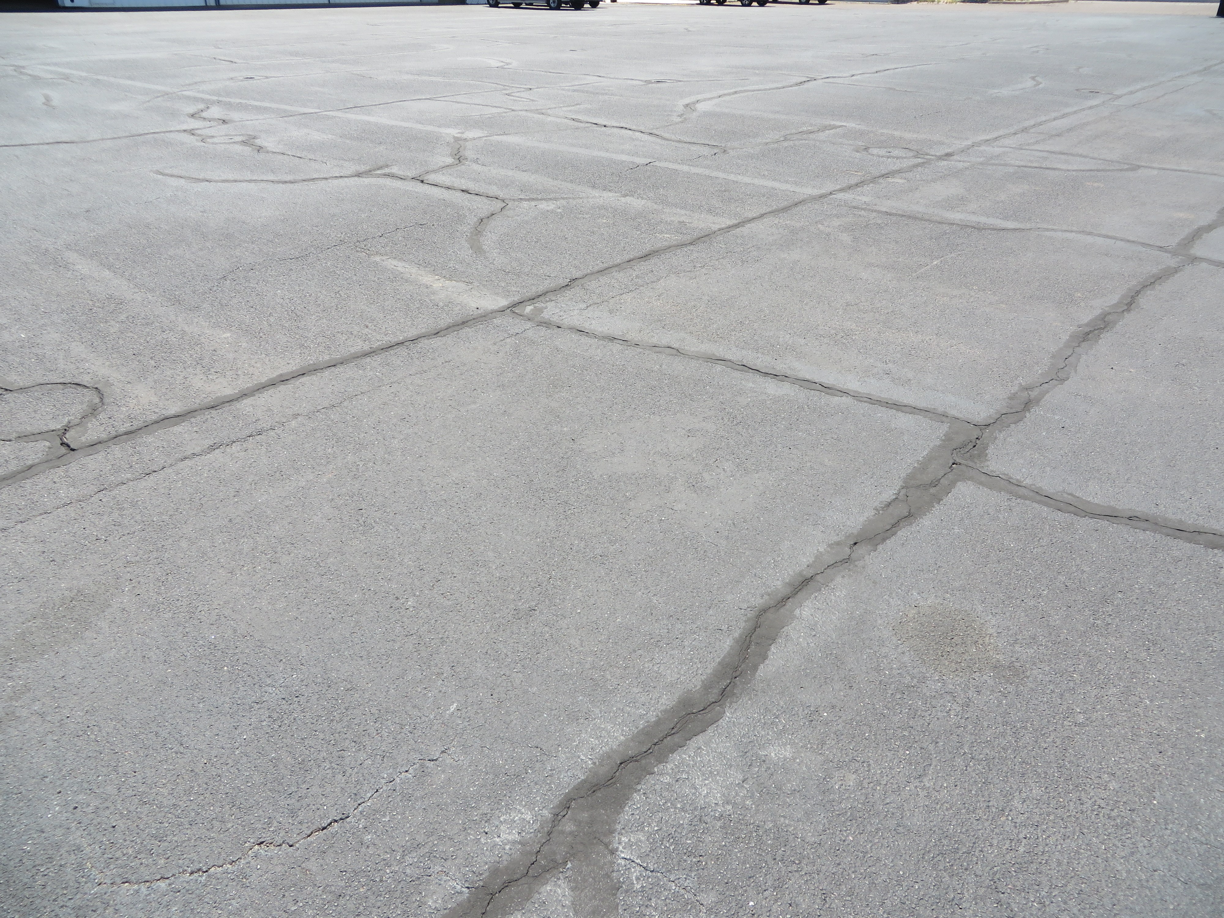 This picture shows an asphalt taxiway pavement with a good amount of block cracking.  The PCI of the pavement in the image is 65.