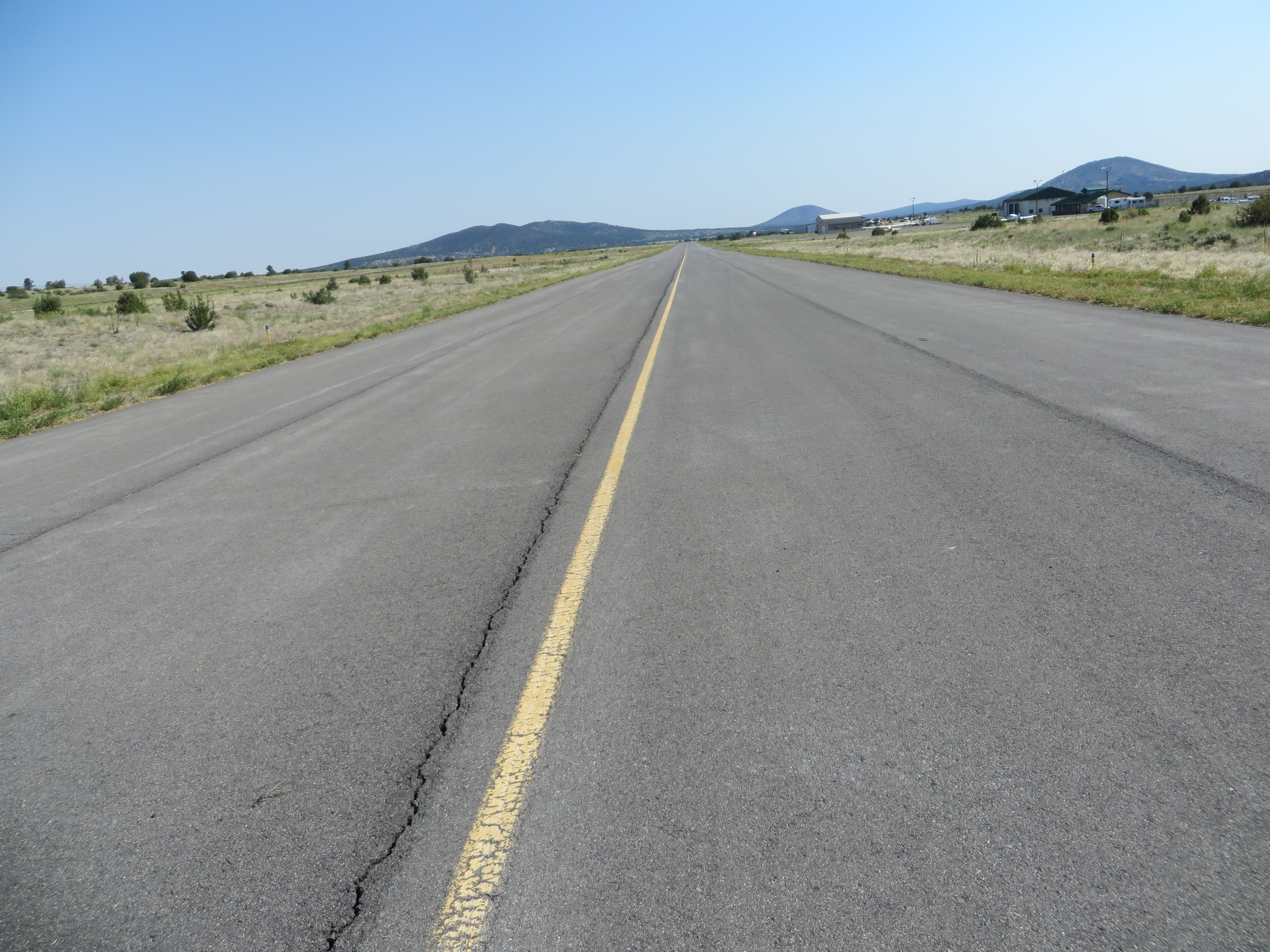 This picture shows an asphalt runway pavement with a single longitudinal paving joint crack.  The PCI of the pavement in the image is 90.